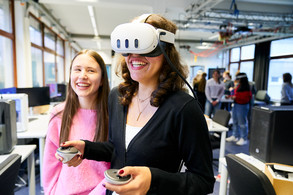 Zwei junge Frauen, eine davon trägt eine VR-Brille